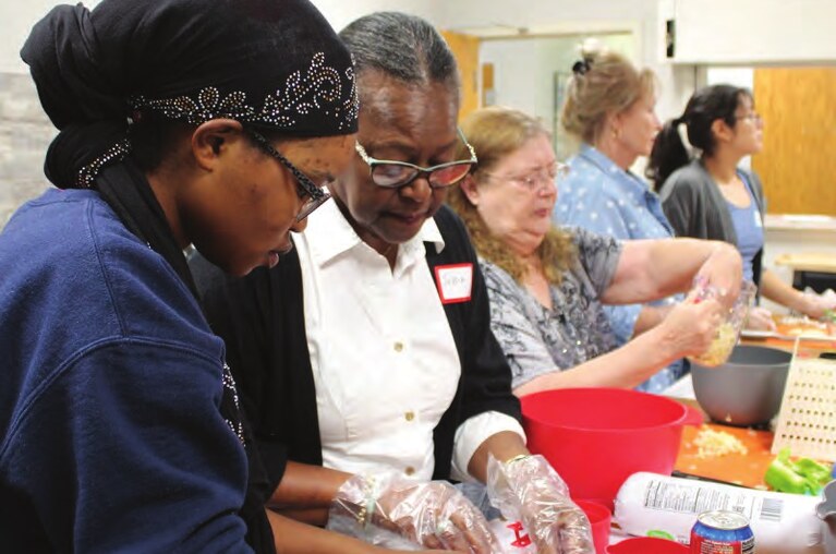 Neighbors and staff preparing food together at a Northside Neighborhood House skill-building class